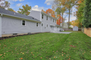 Rear yard of a custom home in the fall by Premier Designs Custom Homes LLC.